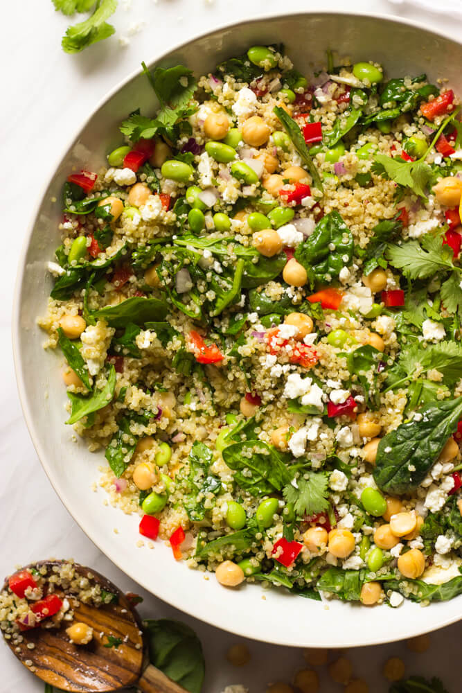 quinoa salad with feta and lemon dressing in a white bowl.