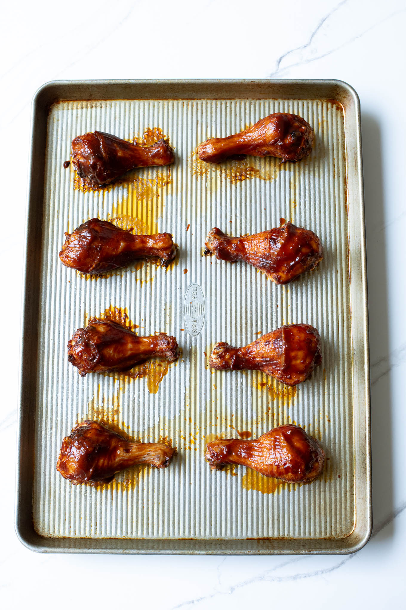 roasted bbq chicken legs on sheet pan.