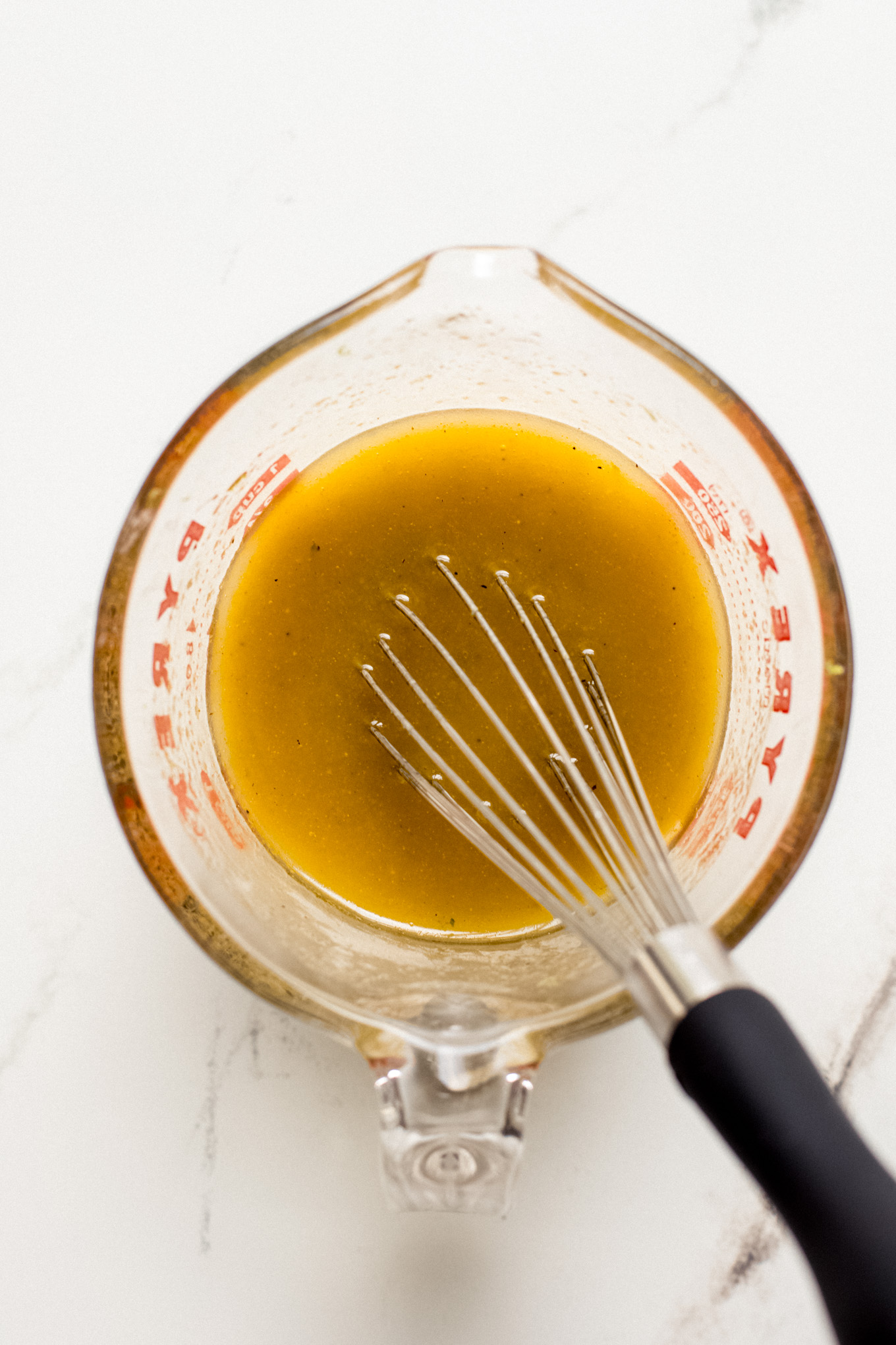 whisked dressing in a glass measuring cup.