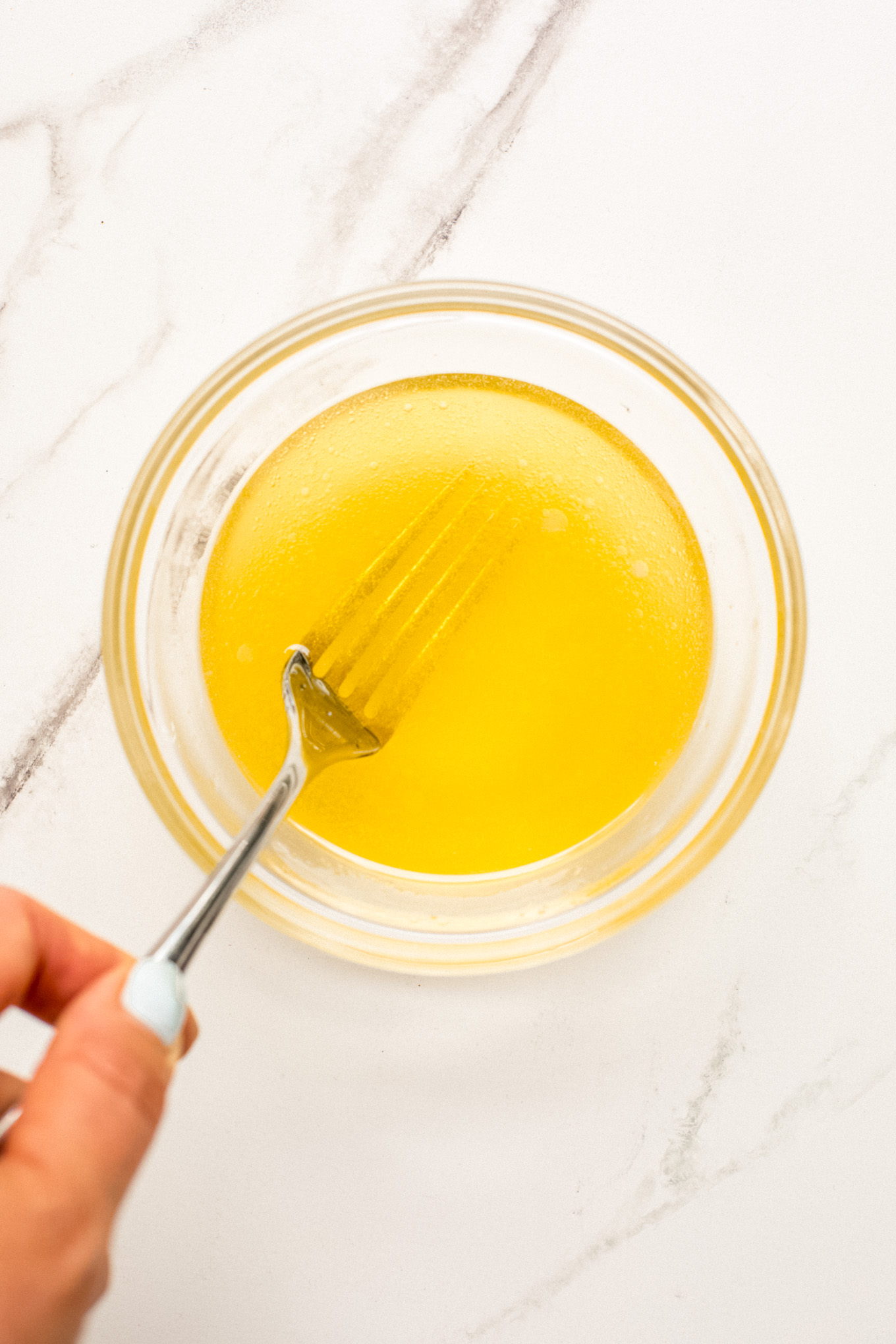 whisked dressing in a glass bowl.