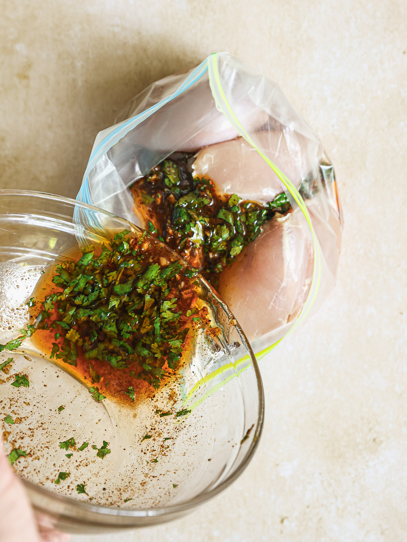 chicken covered in marinade inside a ziploc bag.