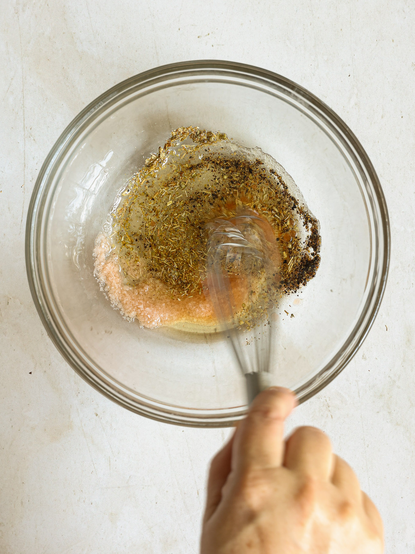 dressing in glass bowl being whisked.