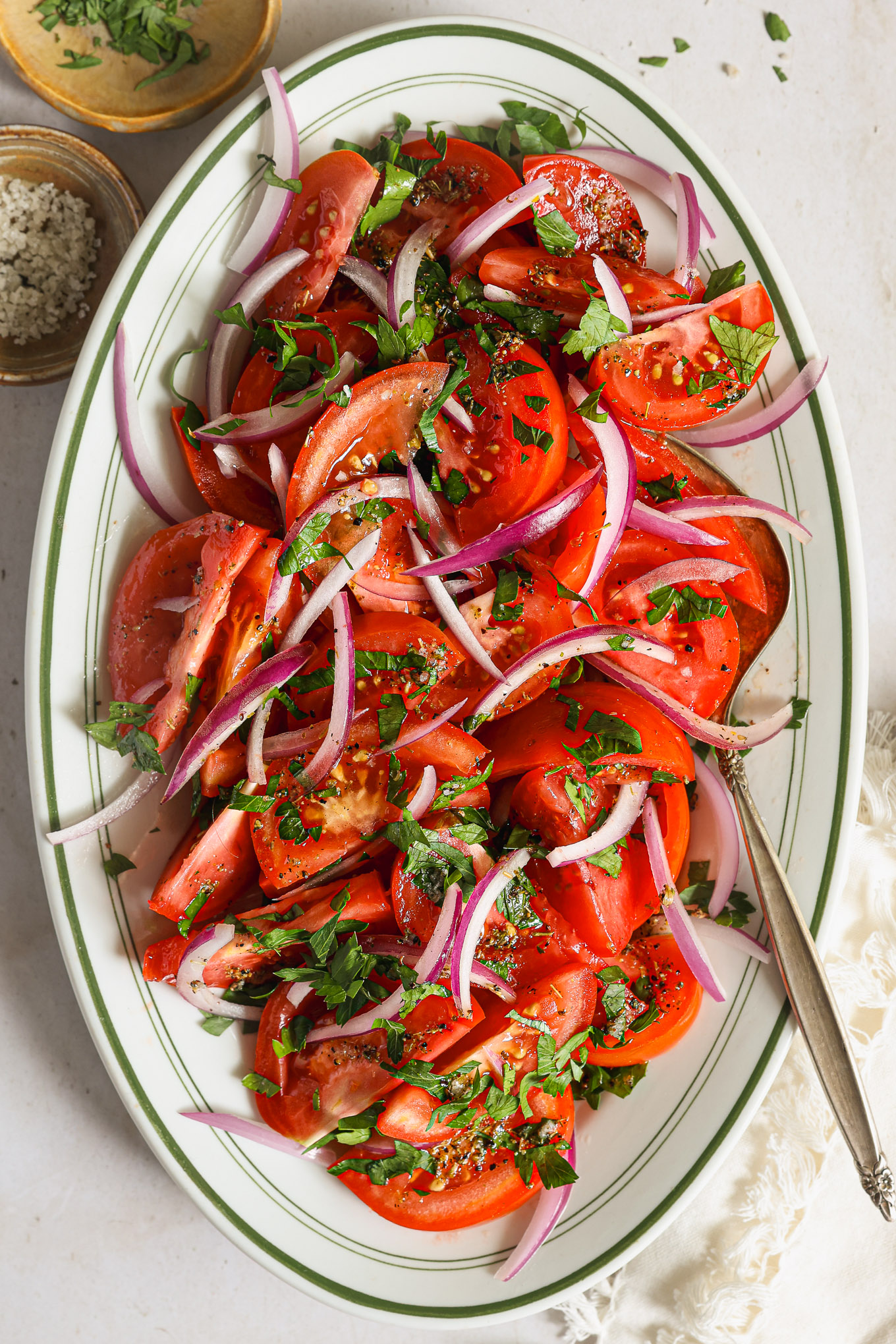 sliced tomatoes topped with red onions and parsley.