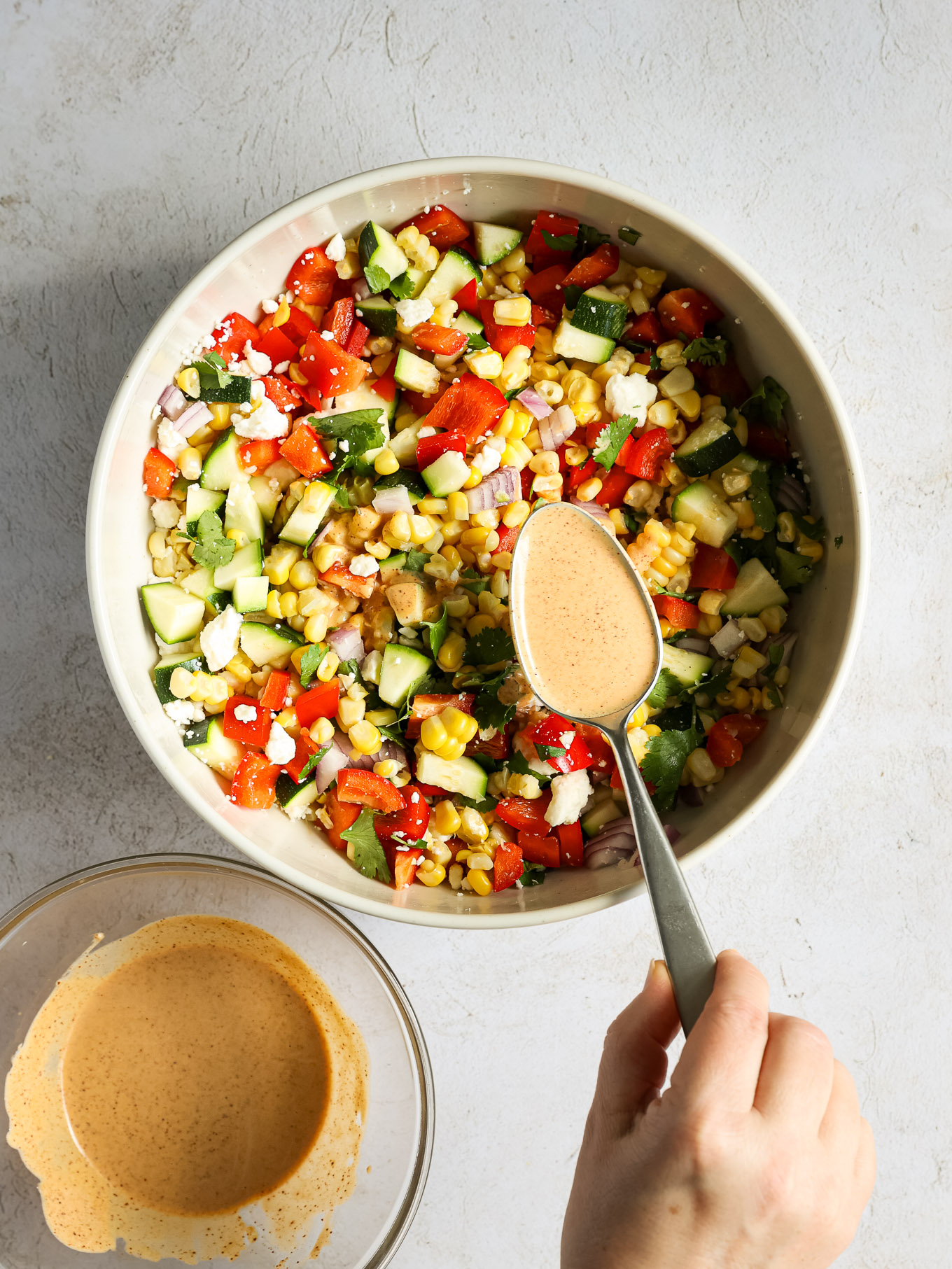 chopped up salad with dressing over it.