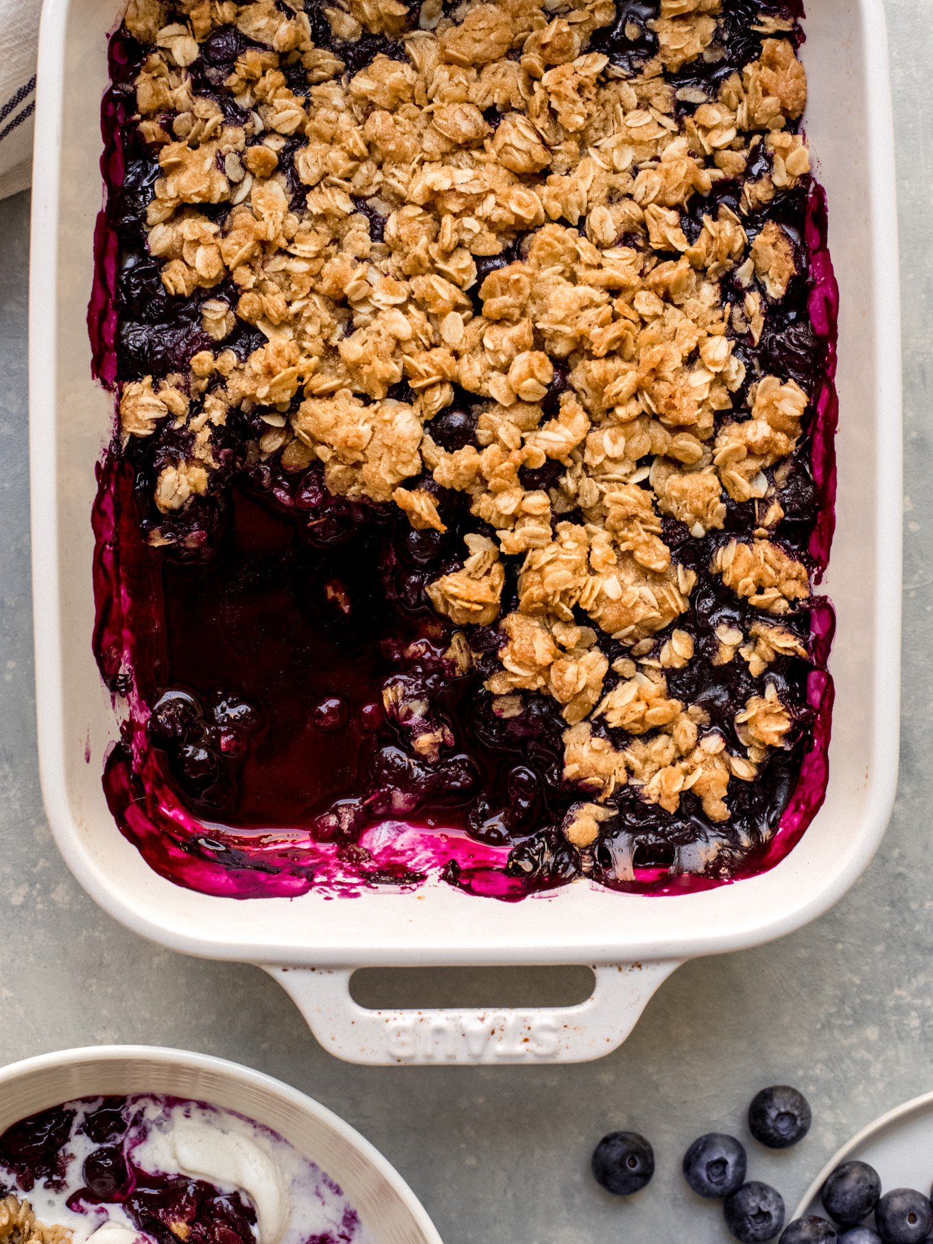 blueberry crisp in a white baking dish.