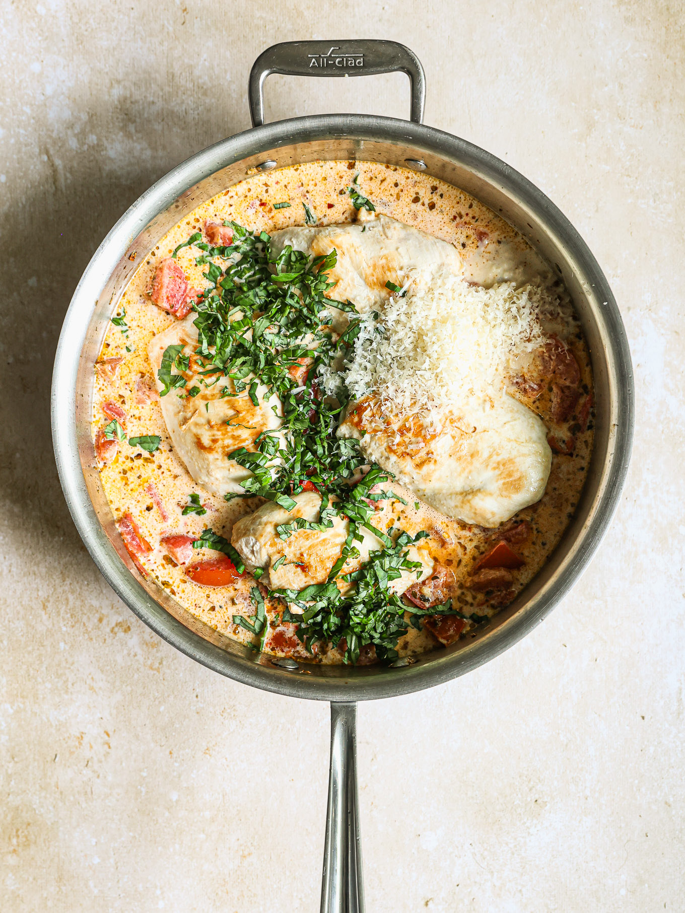 seared chicken breast in a cream sauce topped with fresh basil and parmesan.