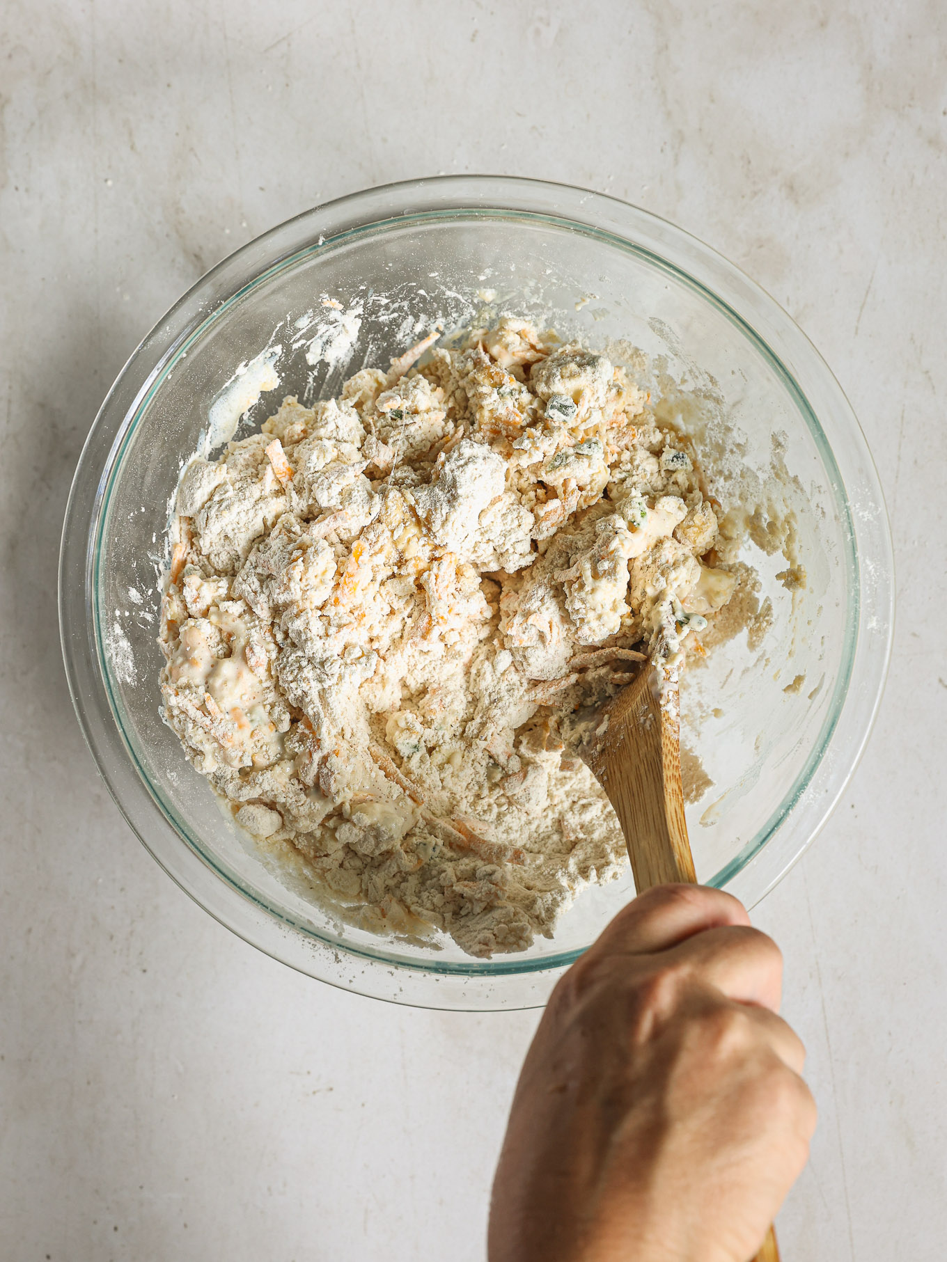 dough mixed inside a bowl with wooden spoon.