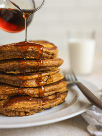 stacked pumpkin pancakes with syrup.