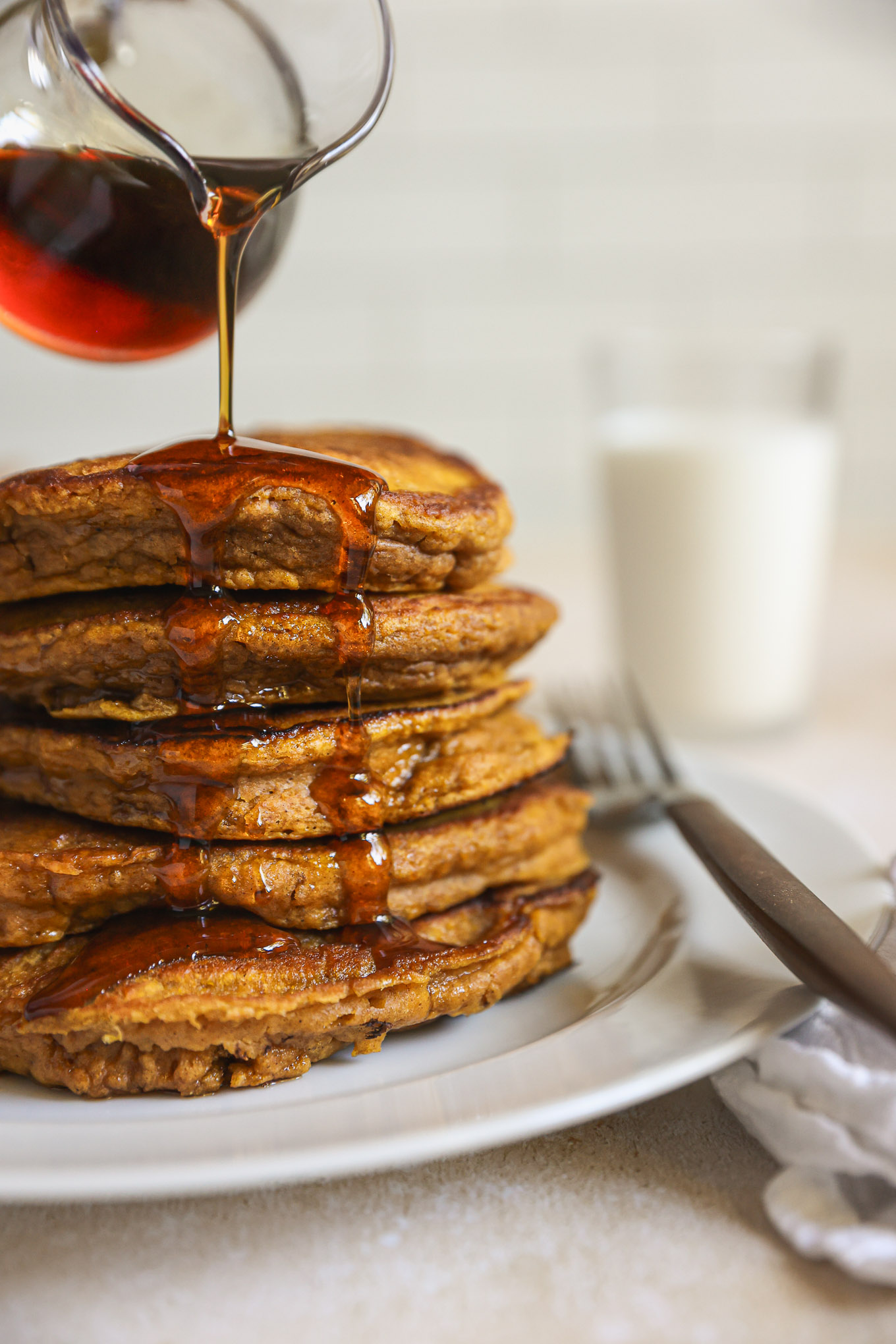 stacked pumpkin pancakes with syrup.